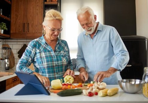 Older couple chopping veggies
